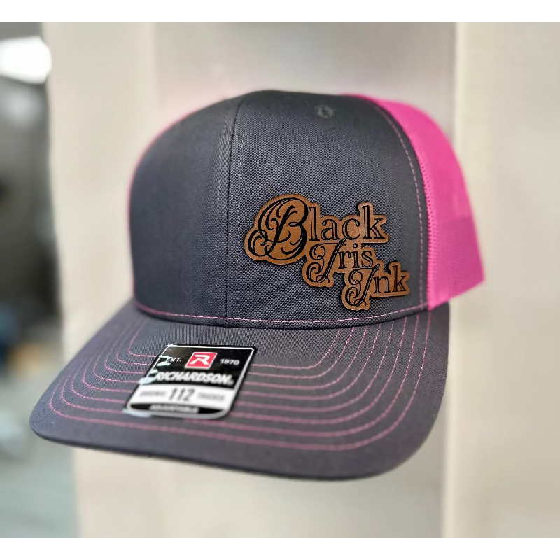 Close up
Gray and pink cap with "Black Iris Ink" logo.