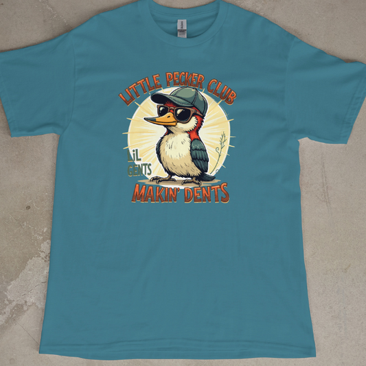 Front View
Blue t-shirt with a cartoon Wood Pecker design and text "Little Pecker Club" laying on a concrete floor.