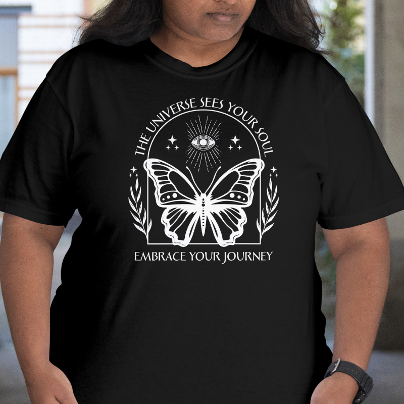 Person wearing a black t-shirt with a butterfly design 'The Universe Sees Your Soul' and text.