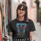 Person wearing a black t-shirt with a colorful butterfly graphic and 'Awaken' text, standing in an urban setting.