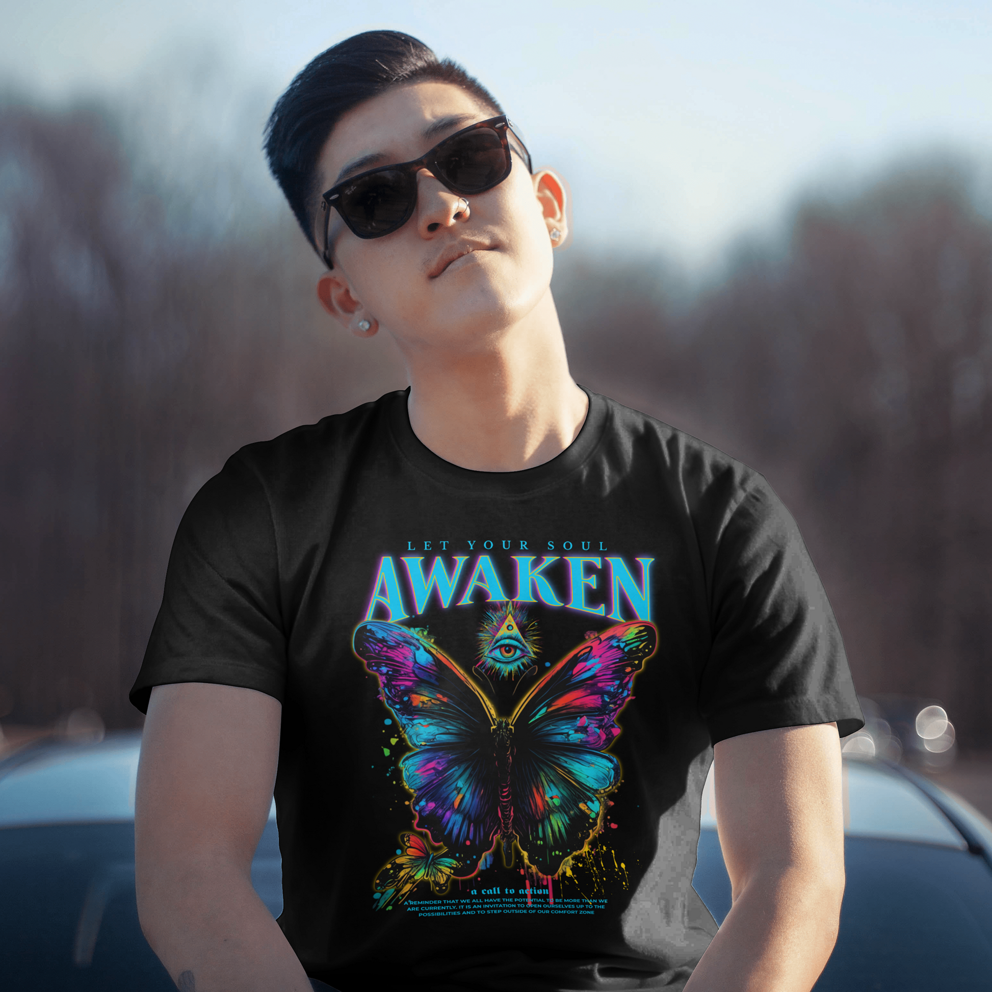 Person wearing a black t-shirt with a colorful butterfly design and 'Awaken' text.