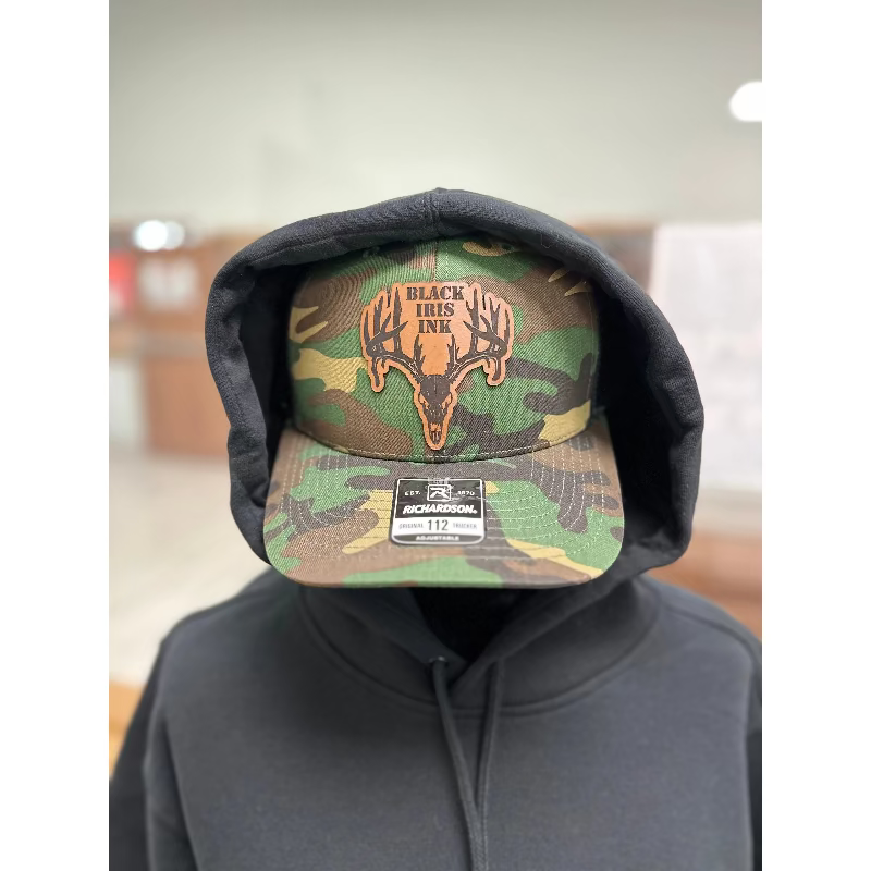 Camoflage hat with a deer skull,  leather patch in the center.