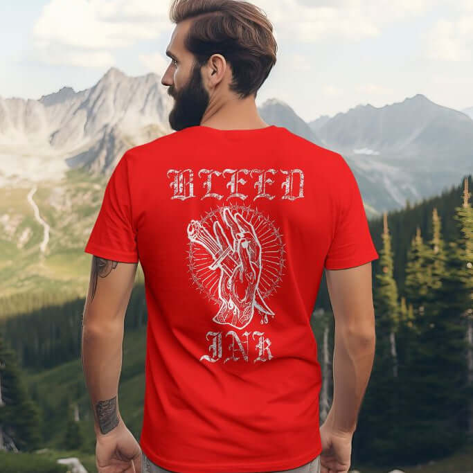 Red Bleed Ink T-Shirt Tattoo Inspired featuring bold artwork on the back of a red shirt against a mountain backdrop.