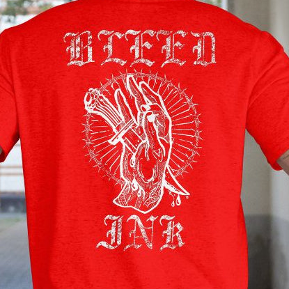 Back View Close up
Person wearing a red t-shirt with white graphic design and text, 'Bleed Ink' standing outdoors.
