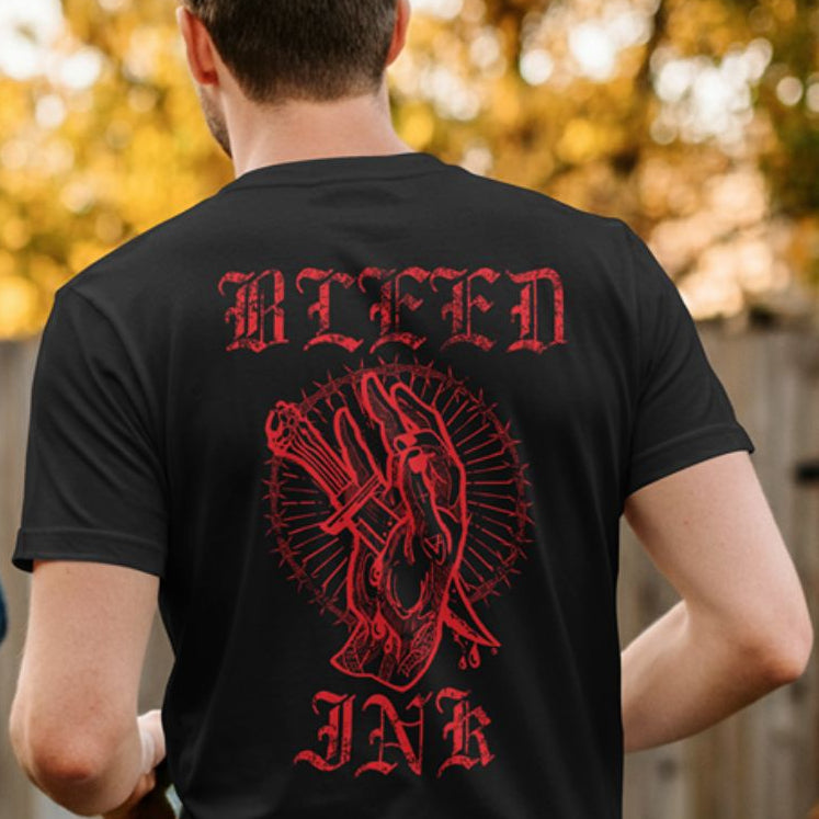 Back View
Person wearing a black t-shirt with red graphic design and text 'BLEED INK' on the back.