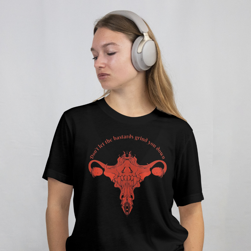 Person wearing a black t-shirt with a red graphic and text, listening to music with headphones.