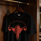 Black t-shirt with red graphic and text on a hanger against a wooden door.