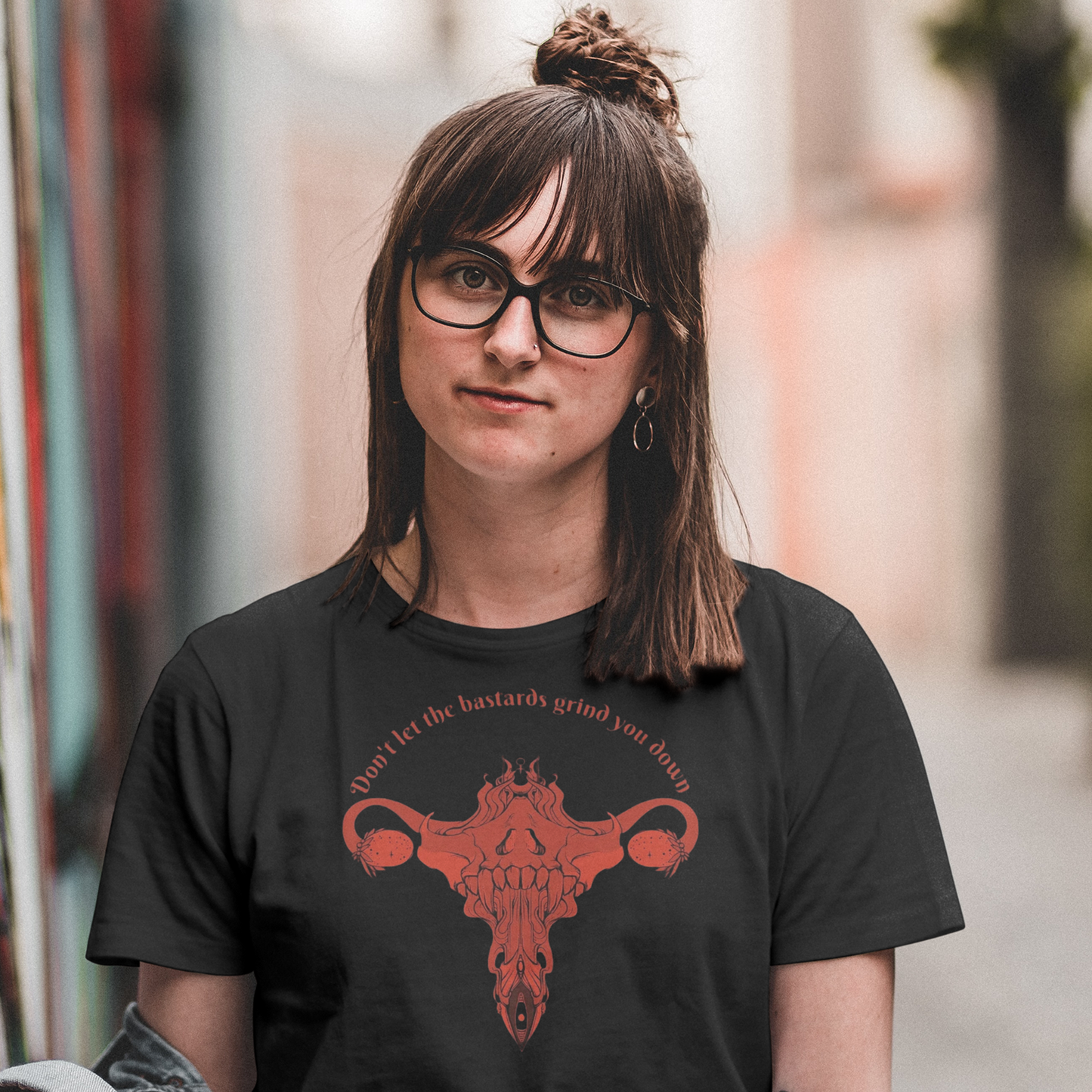 Person wearing a black t-shirt with a red graphic design, standing in an urban setting.