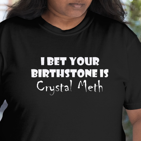 Front View - worn by a model
Person wearing a black t-shirt with humorous text design "I Bet Your Birthstone Is Crystal Meth"