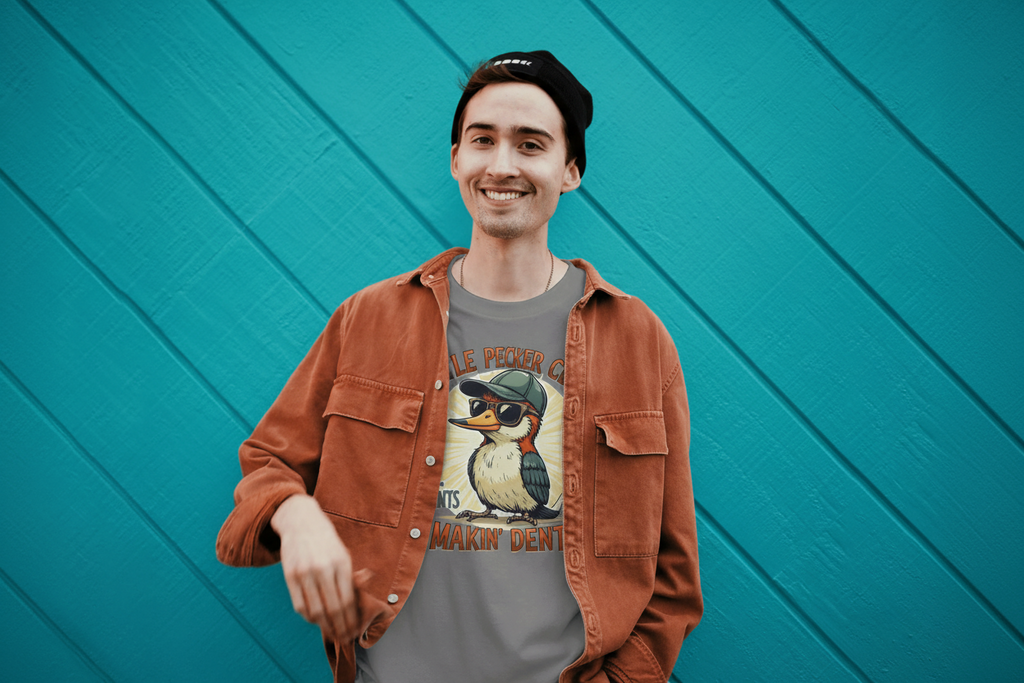 man standing agains a teal back ground with little pecker shirt on
