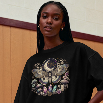 Person wearing a black oversized t-shirt with a colorful graphic design in a gymnasium.