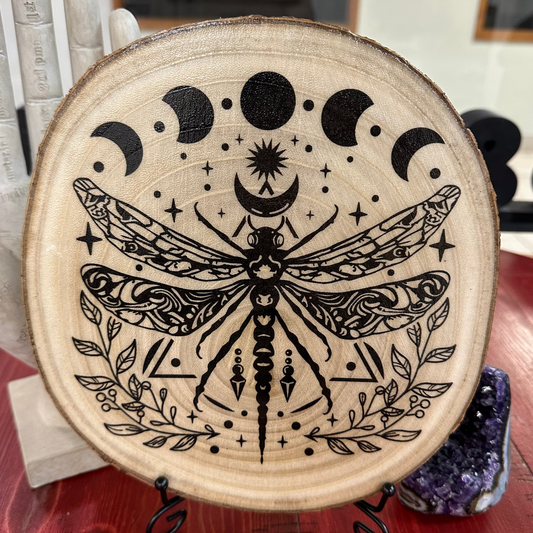 Close Up - Front View on a Stand
Round, Burch, Wooden disk with black dragonfly and moon phase design on a stand.