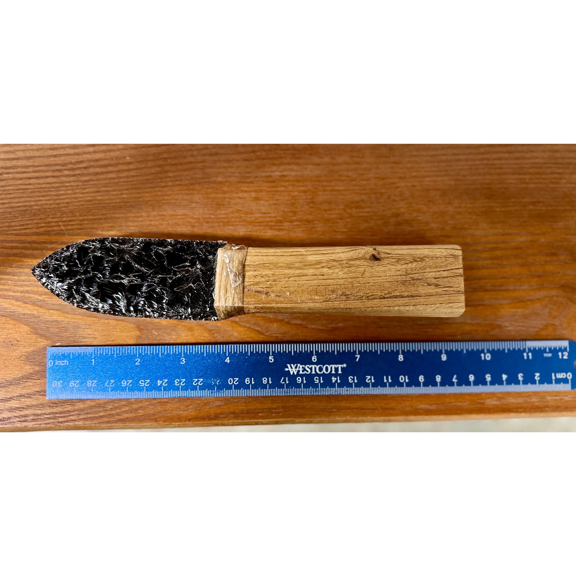 Obsidian knife on a wood surface. 