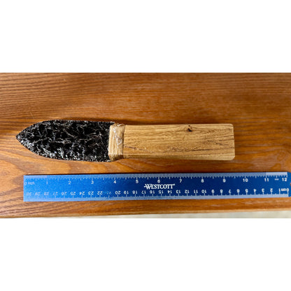 Obsidian knife on a wood surface. 