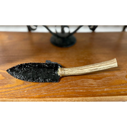 Front View
Obsidian knife sitting on a wood surface.