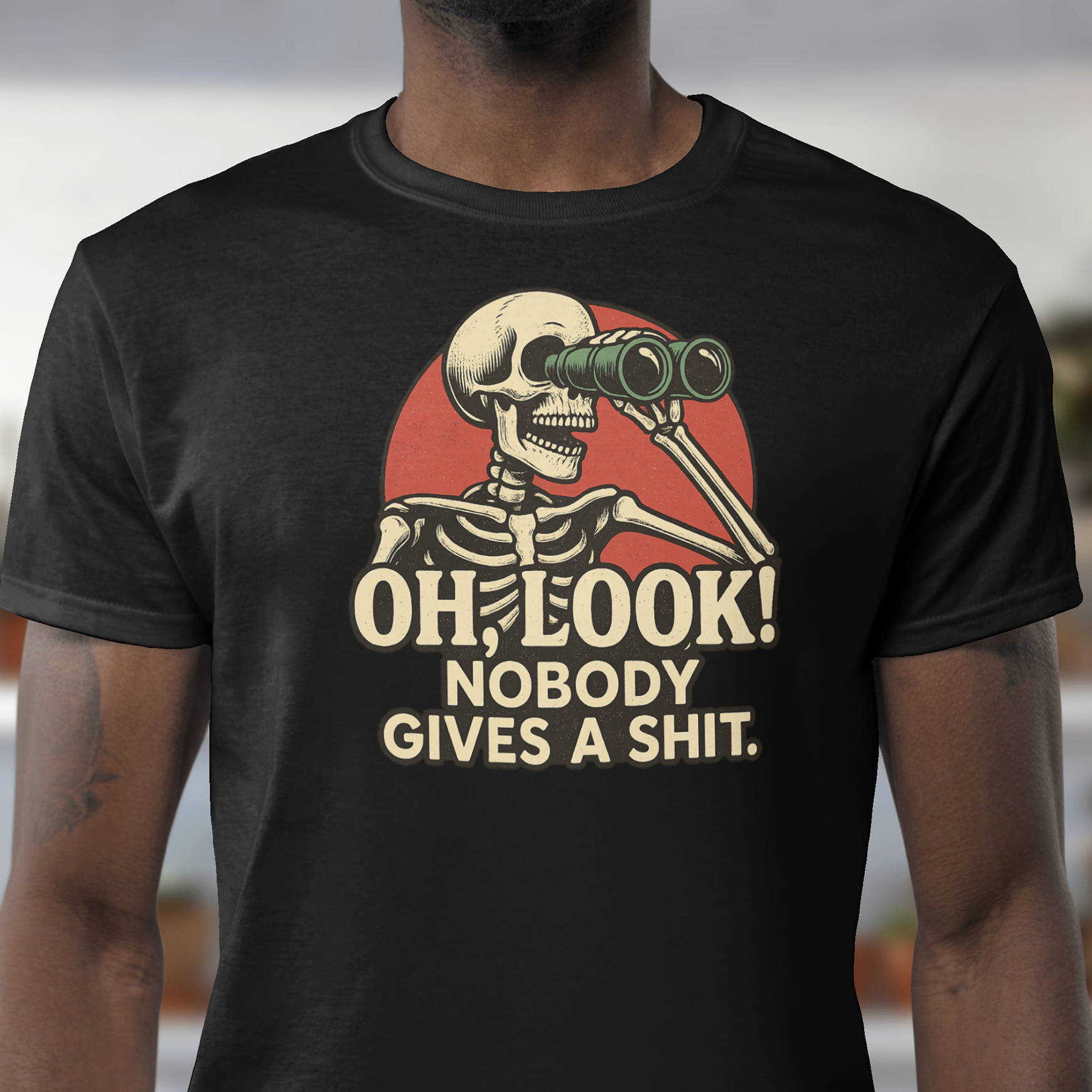 Person wearing a black t-shirt with a skeleton graphic and text outdoors.