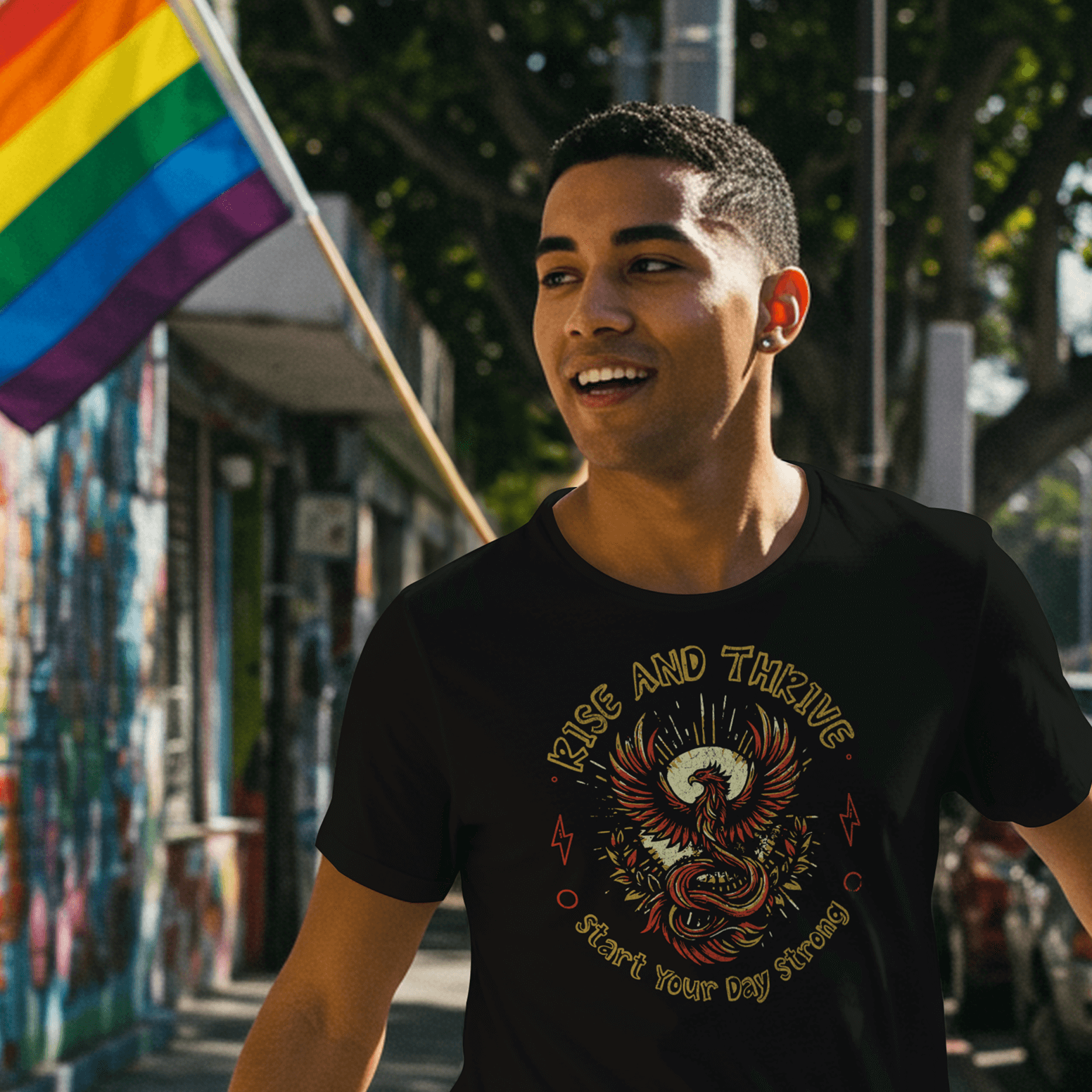 Man walking down a street holding a rainbow flag, wearing a black t-shirt with a graphic design.