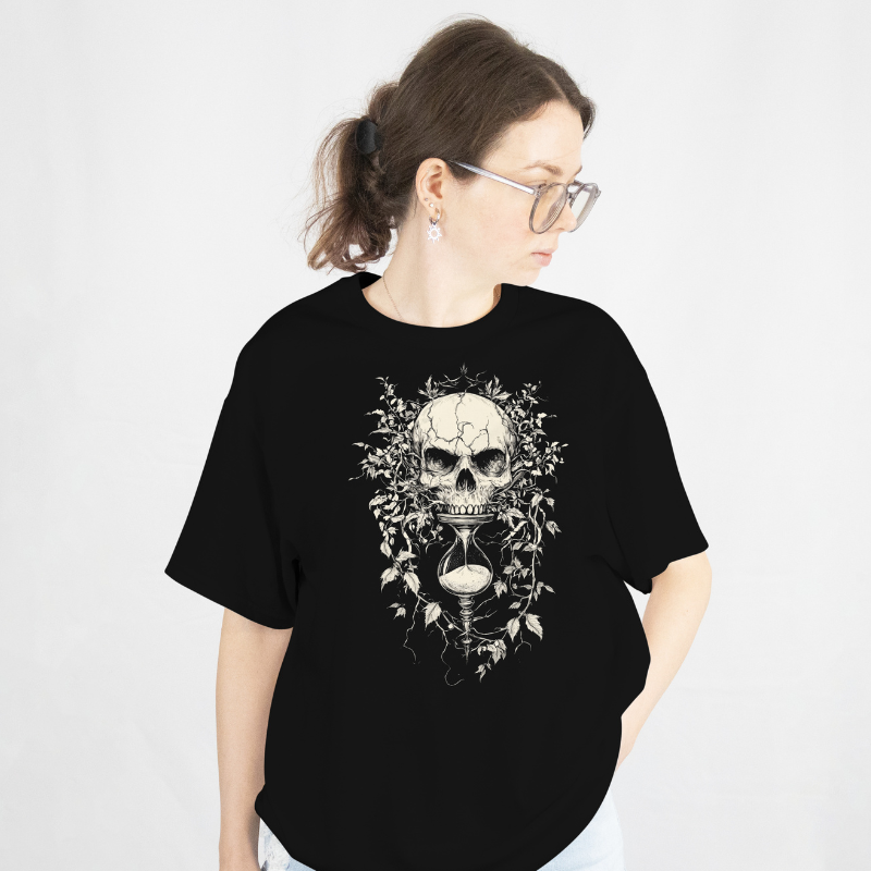 Person wearing a black t-shirt with a skull and hour-glass design on a white background