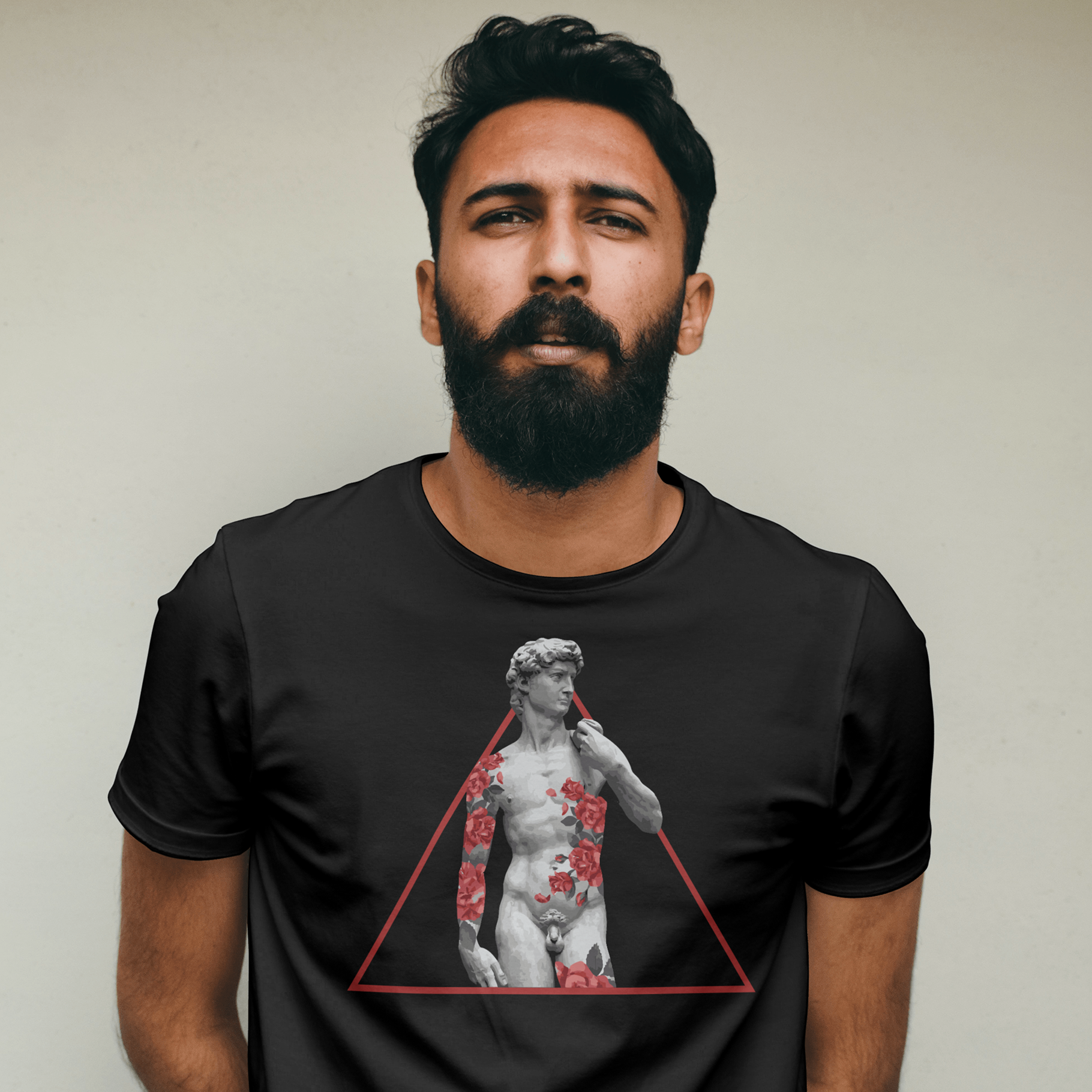 Man wearing a black t-shirt with a graphic design of a statue in a triangle on a plain background
