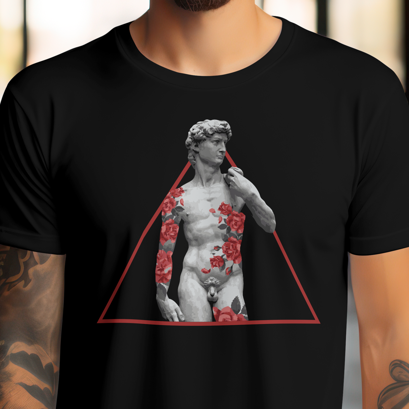 Person wearing a black t-shirt with a graphic design of a statue in a triangle and flowers.
