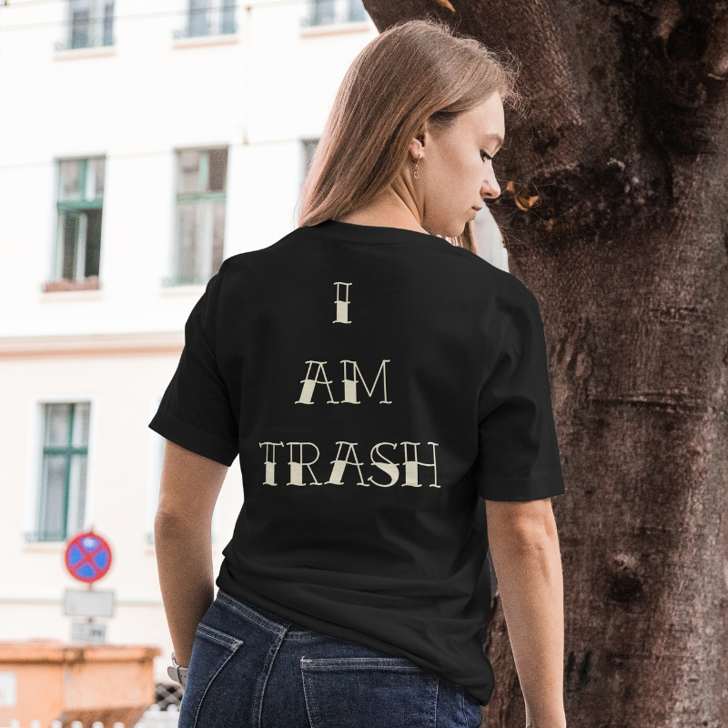 Person wearing a black t-shirt with 'I AM TRASH' text on the back, standing outdoors.