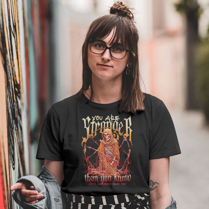 Person wearing a black t-shirt with a graphic design and text, standing in an alleyway.