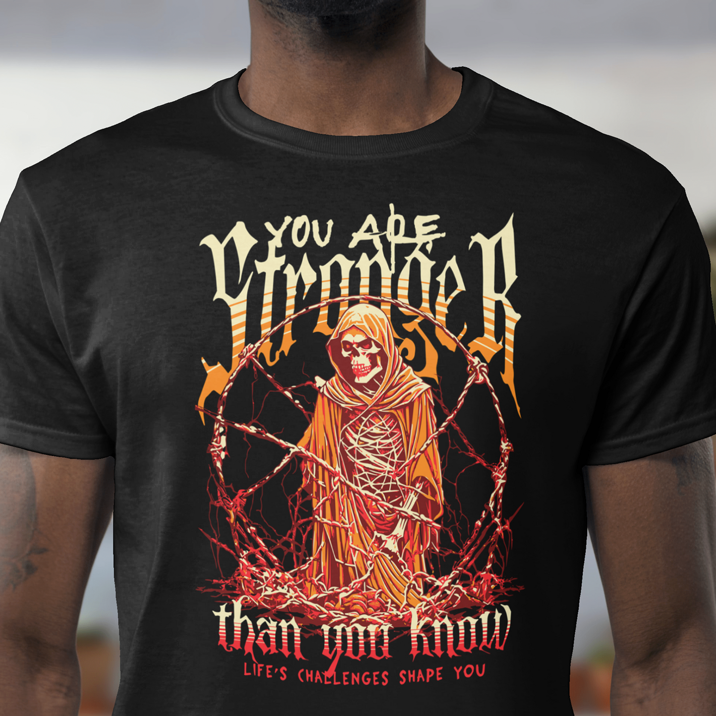 Person wearing a black t-shirt with a graphic design and text, standing outdoors.