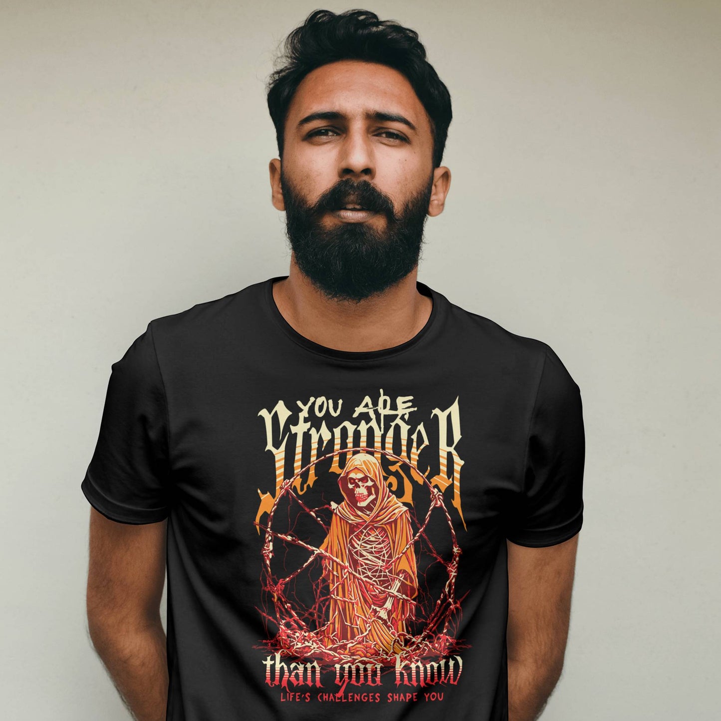 Man wearing a black t-shirt with a graphic design and text against a plain background